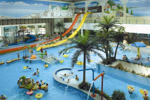 un parque acuático cubierto en un centro comercial con gente dentro en Kumho Hwasun Spa Resort, en Hwasun