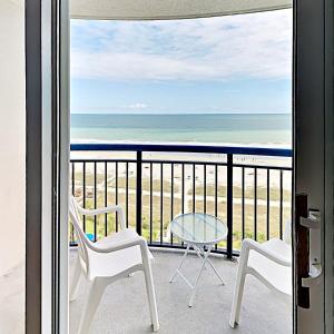 a balcony with a table and chairs and the ocean at Beach Vacation Condos South in Myrtle Beach