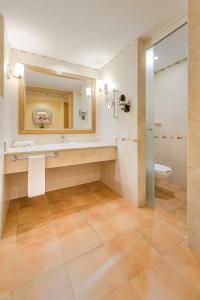 a bathroom with a sink and a toilet and a mirror at Barceló Maya Colonial - All Inclusive in Xpu Ha