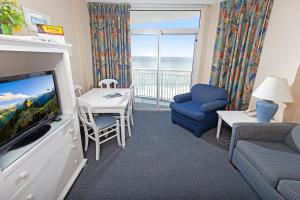 a living room with a tv and a couch and a table at Atlantica Resort in Myrtle Beach