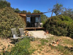 a house with two chairs and a bench in a yard at Montinho Boutique Studio in Benagil