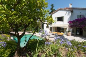 a villa with a swimming pool and a garden at Villa Tsavorite - Cannes Californie in Cannes