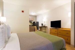 a hotel room with a bed and a flat screen tv at Studio 6-Tucker, GA - Atlanta Northlake in Tucker