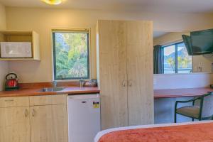 a small kitchen with a sink and a window at Bella Vista Motel Franz Josef Glacier in Franz Josef