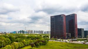 a city with tall buildings and trees and a freeway at Jinling Funhome Hotel Nanjing Jiulong Lake - Nanjing South Railway Station in Nanjing