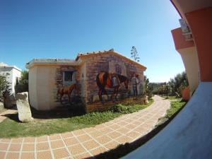 a painting of a horse on the side of a building at Residence Hotel Lu Nibareddu in San Teodoro