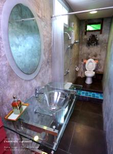 a bathroom with a glass sink and a toilet at Love Bridge House บ้านสะพานรัก in Sangkhla Buri