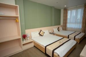 Zimmer mit 2 Betten und einem Fenster in der Unterkunft Huynh Duc 2 Hotel in Cao Lãnh
