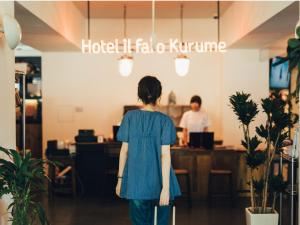 久留米的住宿－Hostel ilfaro Kurume，带着手提箱在商店里走的女人
