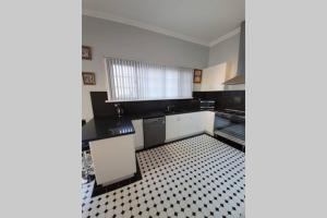 a kitchen with a black and white tiled floor at Bellview Holiday House in Wentworth