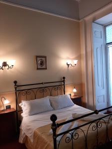 ナポリにあるHotel PIGNATELLI Napoliの白いシーツと窓のあるベッドのある寝室