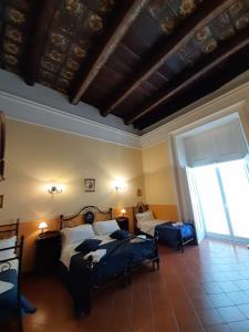 a bedroom with two beds and a large window at Hotel PIGNATELLI Napoli in Naples