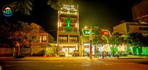 un edificio con luz verde en una calle por la noche en Huynh Duc Hotel, en Cao Lãnh