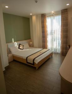 1 dormitorio con cama grande y ventana grande en Huynh Duc 2 Hotel en Cao Lãnh