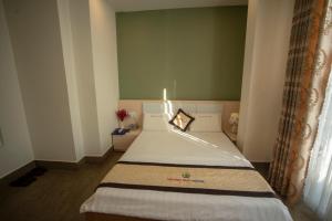 Un dormitorio con una cama con una vela. en Huynh Duc 2 Hotel, en Cao Lãnh