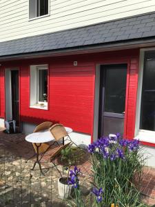 a red house with a bench and flowers in front of it at CHAMBRE La Petite VENISE in Pont-Audemer +3 photos