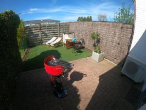 a small backyard with a red basket on a patio at House & garden l'Hippodrome in Bredene