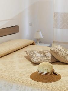 2 letti con cuscini e un cappello sopra di essi di Apartment Stella Maris a Cala Gonone