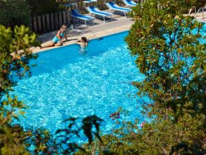 two girls are playing in a swimming pool at Residence Hotel Lu Nibareddu in San Teodoro