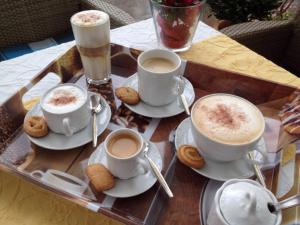 ein Tablett mit Tassen Kaffee und Keksen auf dem Tisch in der Unterkunft Hotel Johann in Warendorf