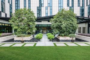 a courtyard with trees in front of a building at Holiday Inn Express Shanghai Gongkang, an IHG Hotel in Baoshan