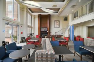 a cafeteria with tables and chairs and a television at Holiday Inn Express Hotel & Suites Port Clinton-Catawba Island by IHG in Port Clinton