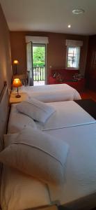 a bedroom with four beds with white pillows at La Quintana del Cuera in Parres de Llanes