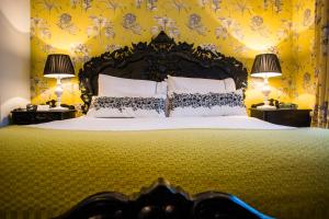 a bedroom with a large bed with two lamps at Beachlands Hotel in Weston-super-Mare