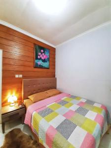 a bedroom with a bed and a painting on the wall at Rumah Sorai in Batu