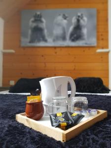 a tray with a coffee mug and glasses on a bed at Gîte Chalet du Soulor in Arrens-Marsous