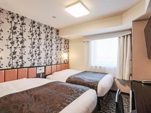 a hotel room with two beds and a window at APA Hotel & Resort Yokohama Bay Tower in Yokohama