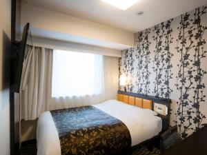 a bedroom with a bed and a window at APA Hotel & Resort Yokohama Bay Tower in Yokohama