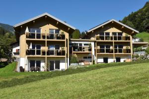 a large house on a hill with green grass at Appartments Urmonti in Schruns