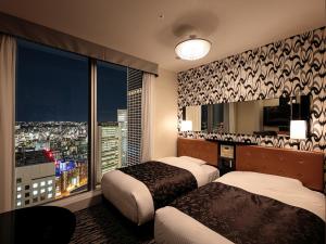 a hotel room with two beds and a large window at APA Hotel & Resort Yokohama Bay Tower in Yokohama