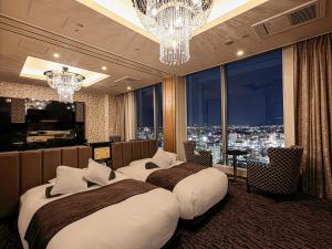 two beds in a hotel room with a view of the city at APA Hotel & Resort Yokohama Bay Tower in Yokohama