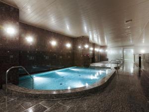 a large swimming pool in a building with lights at APA Hotel & Resort Yokohama Bay Tower in Yokohama