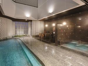 a large bathroom with a swimming pool and a tub at APA Hotel & Resort Yokohama Bay Tower in Yokohama