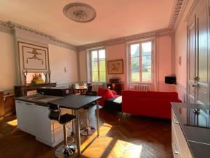 a living room with a table and a red couch at Lysbed - Chevreul in Angers