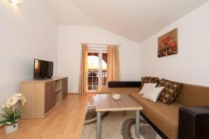 a living room with a couch and a tv at Apartments Simovic in Tučepi