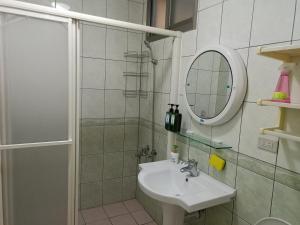 a bathroom with a sink and a mirror and a shower at Fish Hostel in Yingge