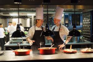 two chefs standing in a kitchen preparing food at Thon Hotel Bergen Airport in Bergen