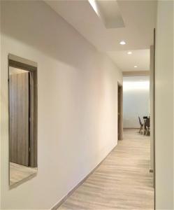 um corredor vazio com paredes brancas e pisos de madeira em More Athens Apartments em Atenas