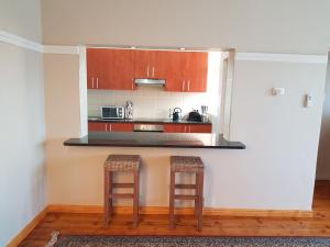 a kitchen with two stools and a counter top at Bramber Court Art-Deco Self-Catering Apartments in Cape Town