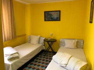 twee bedden in een kamer met gele muren bij Hotel Continental in Roşiori de Vede