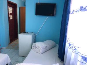 Cette chambre bleue dispose d'un réfrigérateur et d'une télévision murale. dans l'établissement Hotel Continental, à Roşiori de Vede