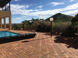 a swimming pool with a light next to a house at Felsenblick Self-Catering in Windhoek