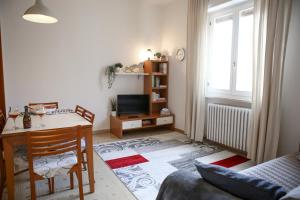 sala de estar con mesa y escritorio con TV en Appartamento al Birrificio, en Valeggio sul Mincio