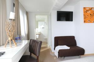ein Wohnzimmer mit einem Schreibtisch und einem Stuhl in der Unterkunft Hotel Weinlaube in Koblenz