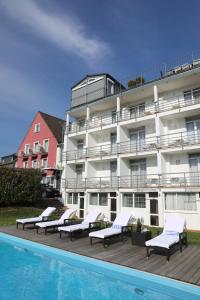 ein Hotel mit einem Pool neben einem Gebäude in der Unterkunft Hotel Weinlaube in Koblenz