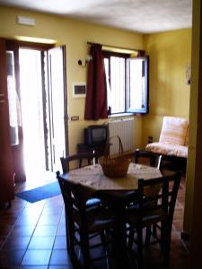 a living room with a table and chairs and a bedroom at Il Ritrovo degli Angeli in San Mauro Cilento